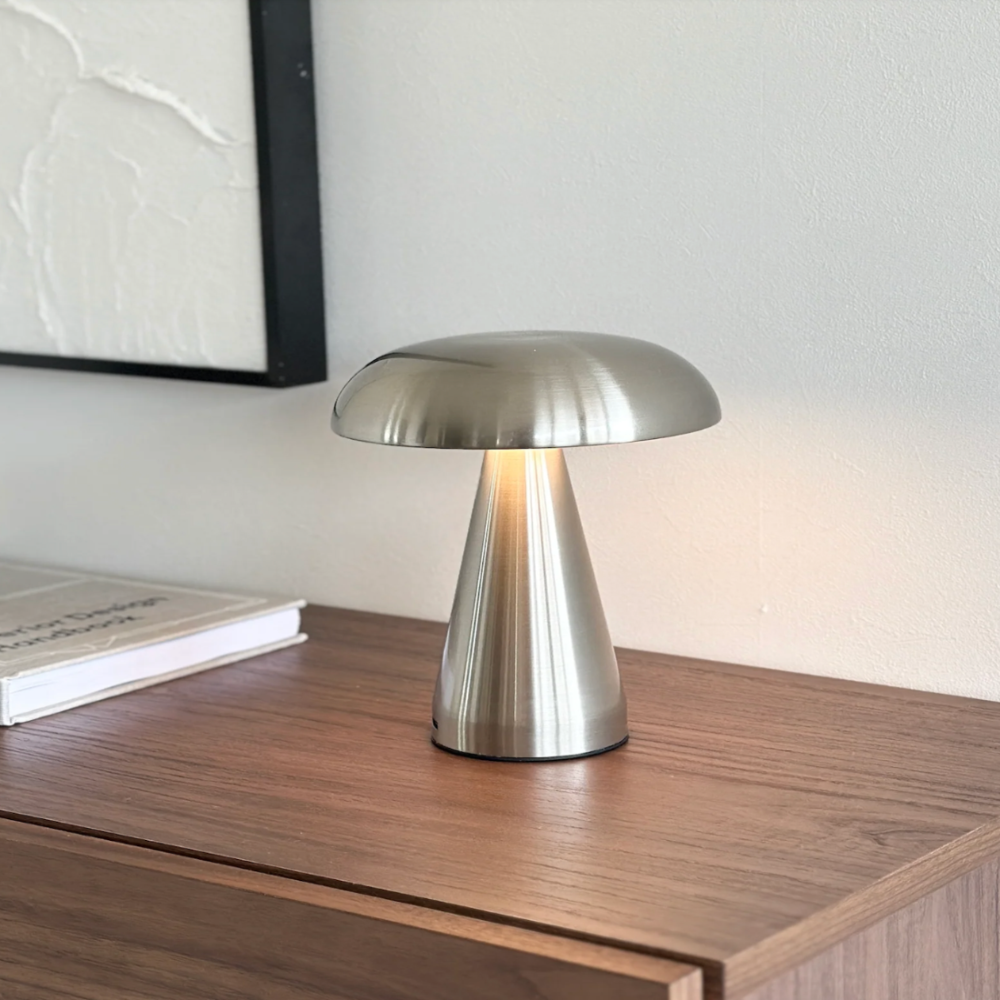 Silver table lamp on a wooden surface with a neutral background
