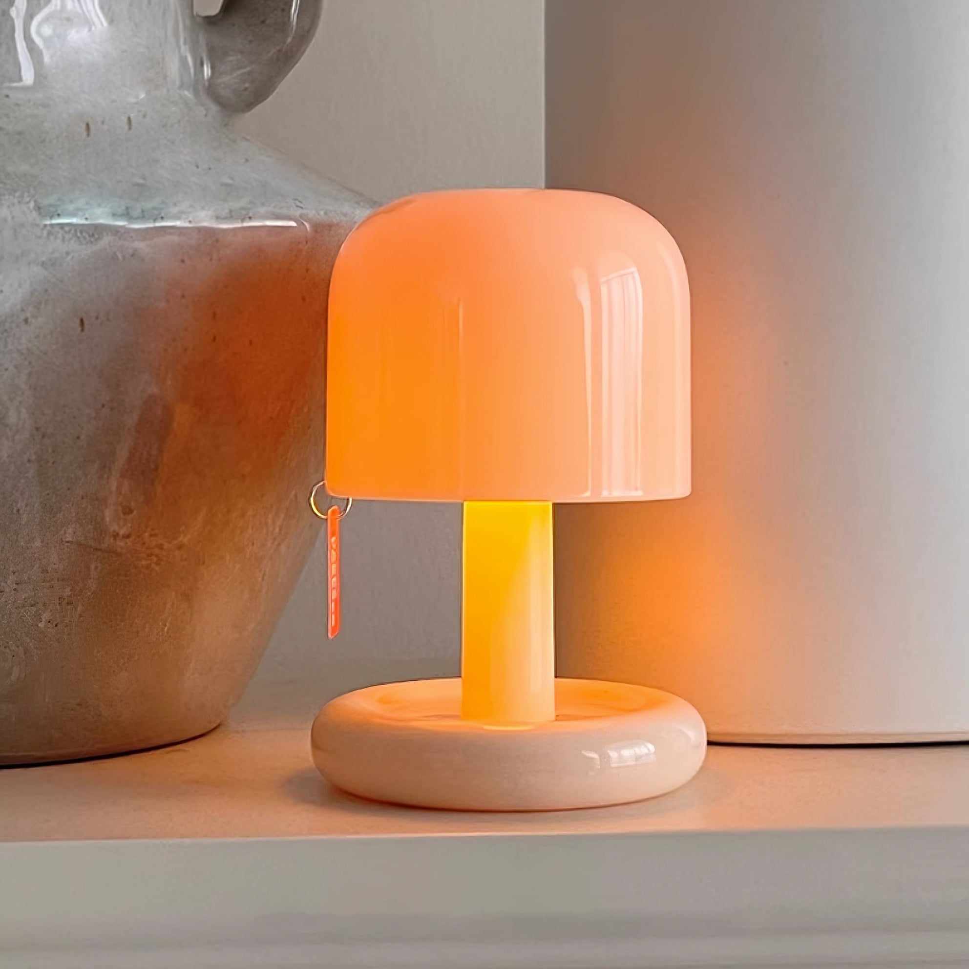 Small orange lamp on a surface with a neutral background