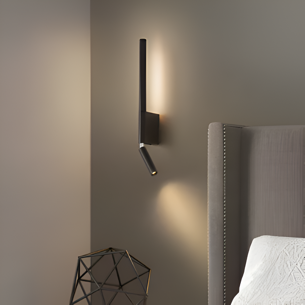 Modern wall-mounted light fixture on a gray wall next to a bed.