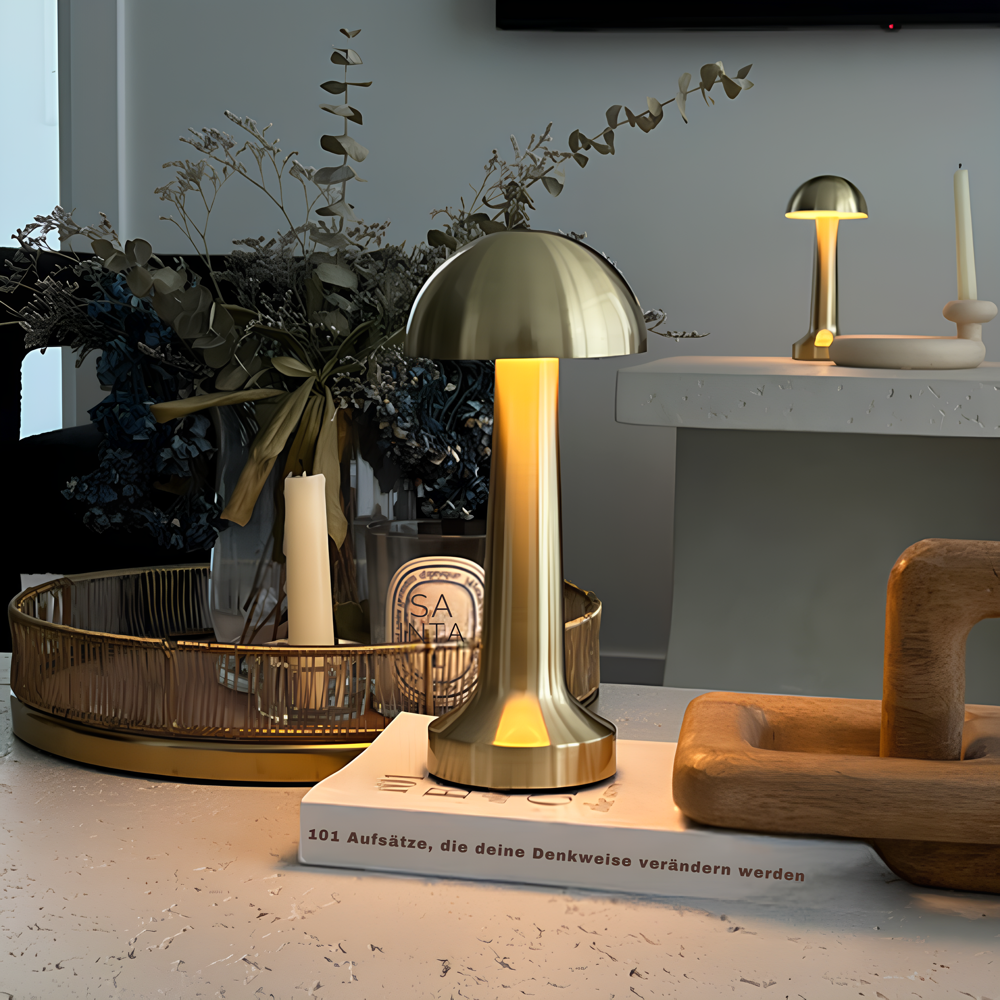 Gold table lamp on a book with decorative items in the background