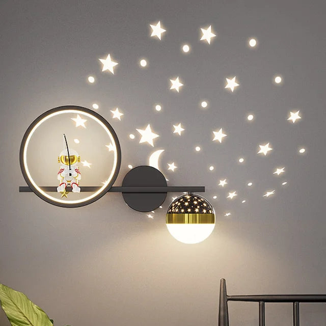 Decorative wall light fixture with star decals on a gray wall.