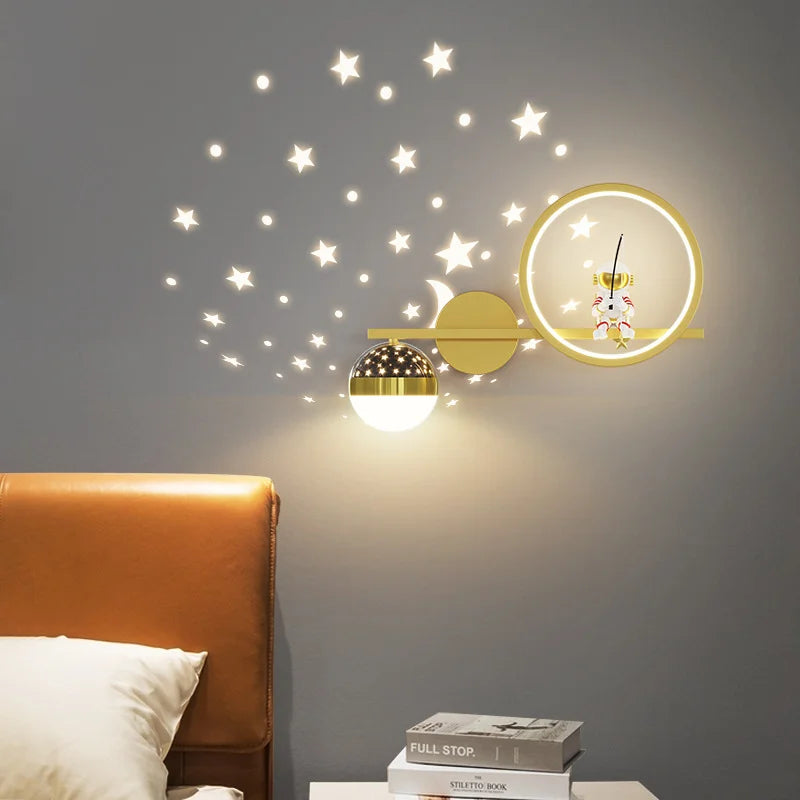 Decorative wall lights with star stickers on a gray wall above a bed.