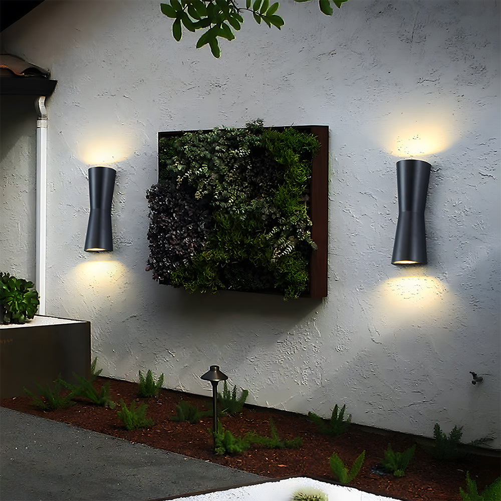Outdoor lamp on a texture wall with a plant