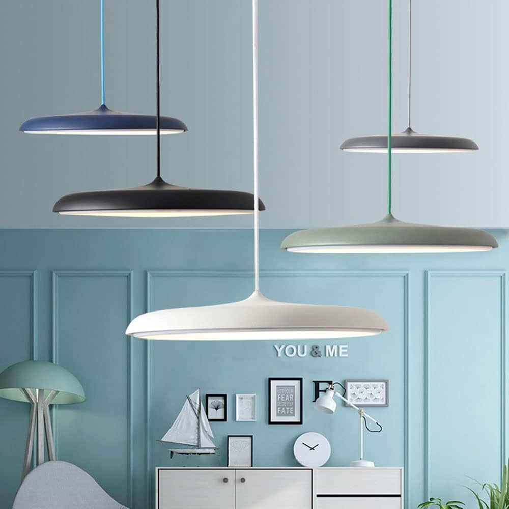 Four pendant lights hanging against a blue paneled wall with decorative elements.