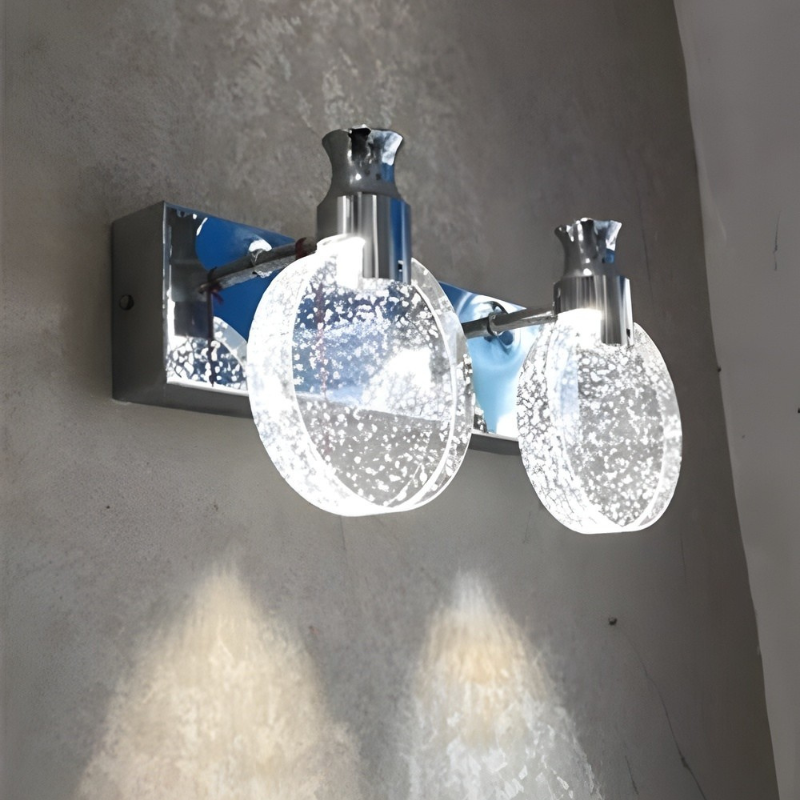 Wall-mounted light fixture with two glass globe shades on a gray wall.