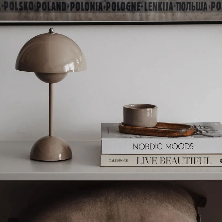 Decorative lamp and books on a shelf with a neutral background