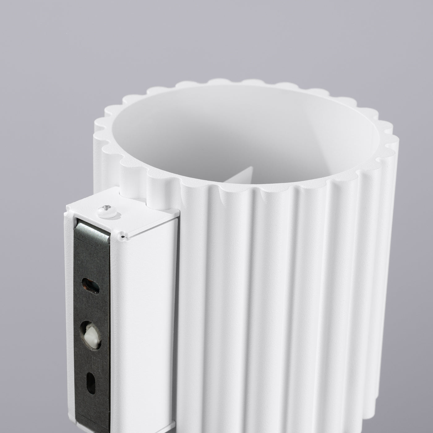 White cylindrical object with ribbed design on a gray background