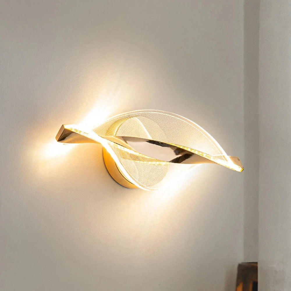Modern wall sconce with gold leaf design on a white wall