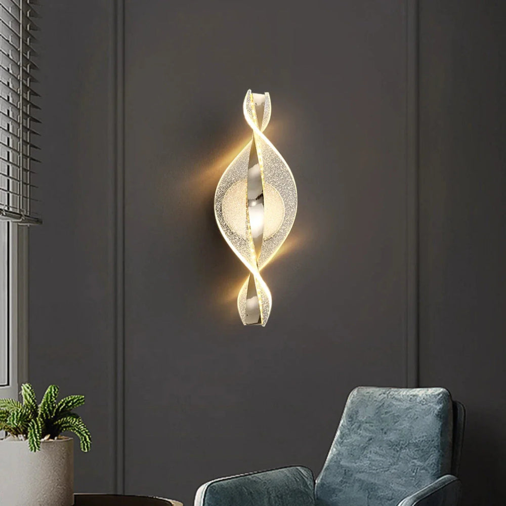 Decorative wall light fixture on a dark gray wall with a blue armchair and plant in the foreground.