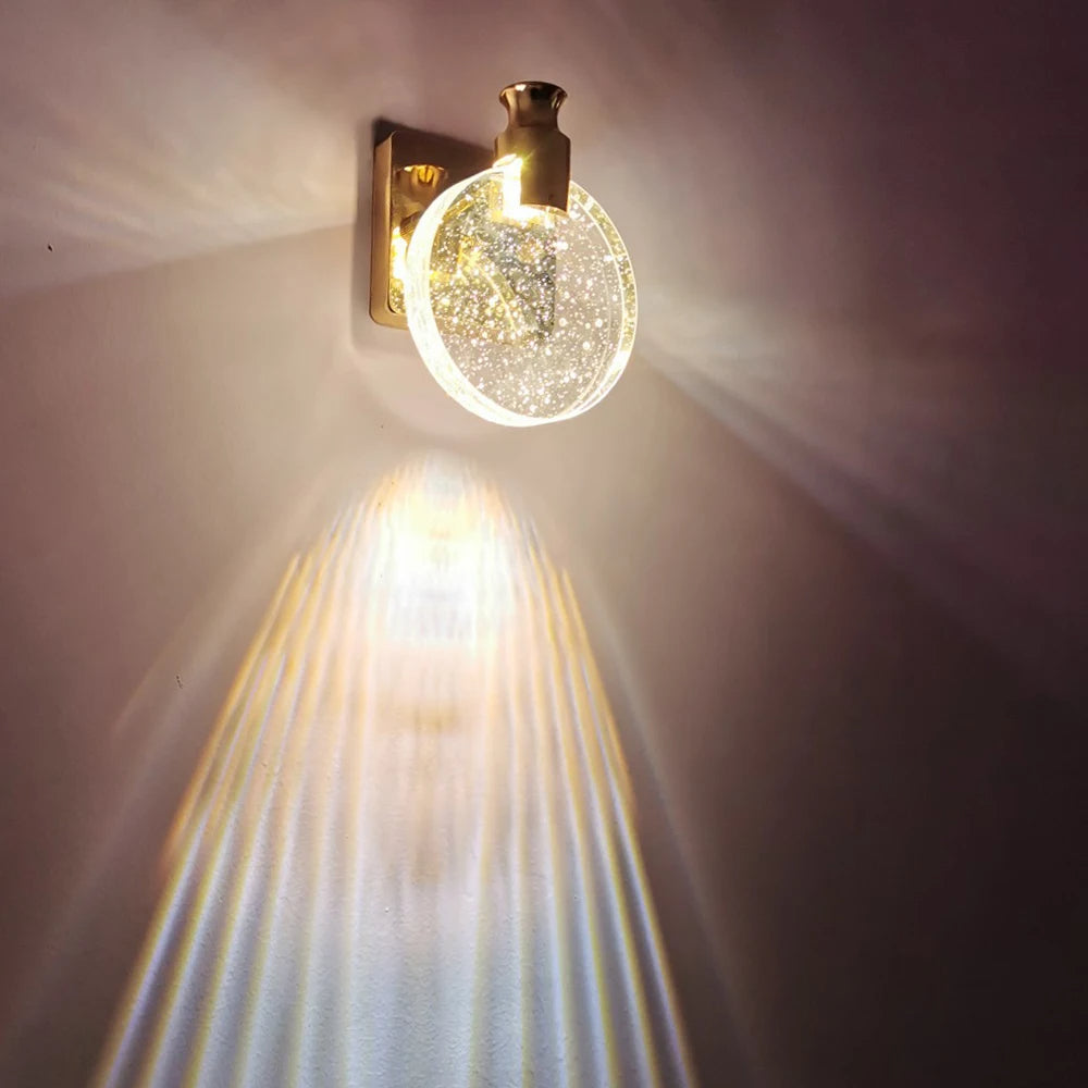 Decorative wall light fixture with a glowing bulb on a plain wall.