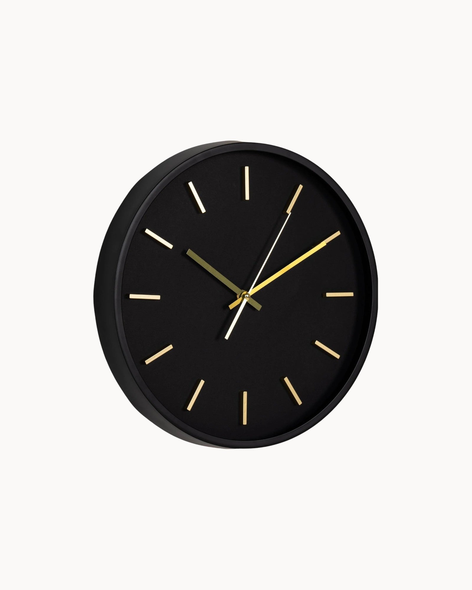 Black wall clock with gold hands on a white background