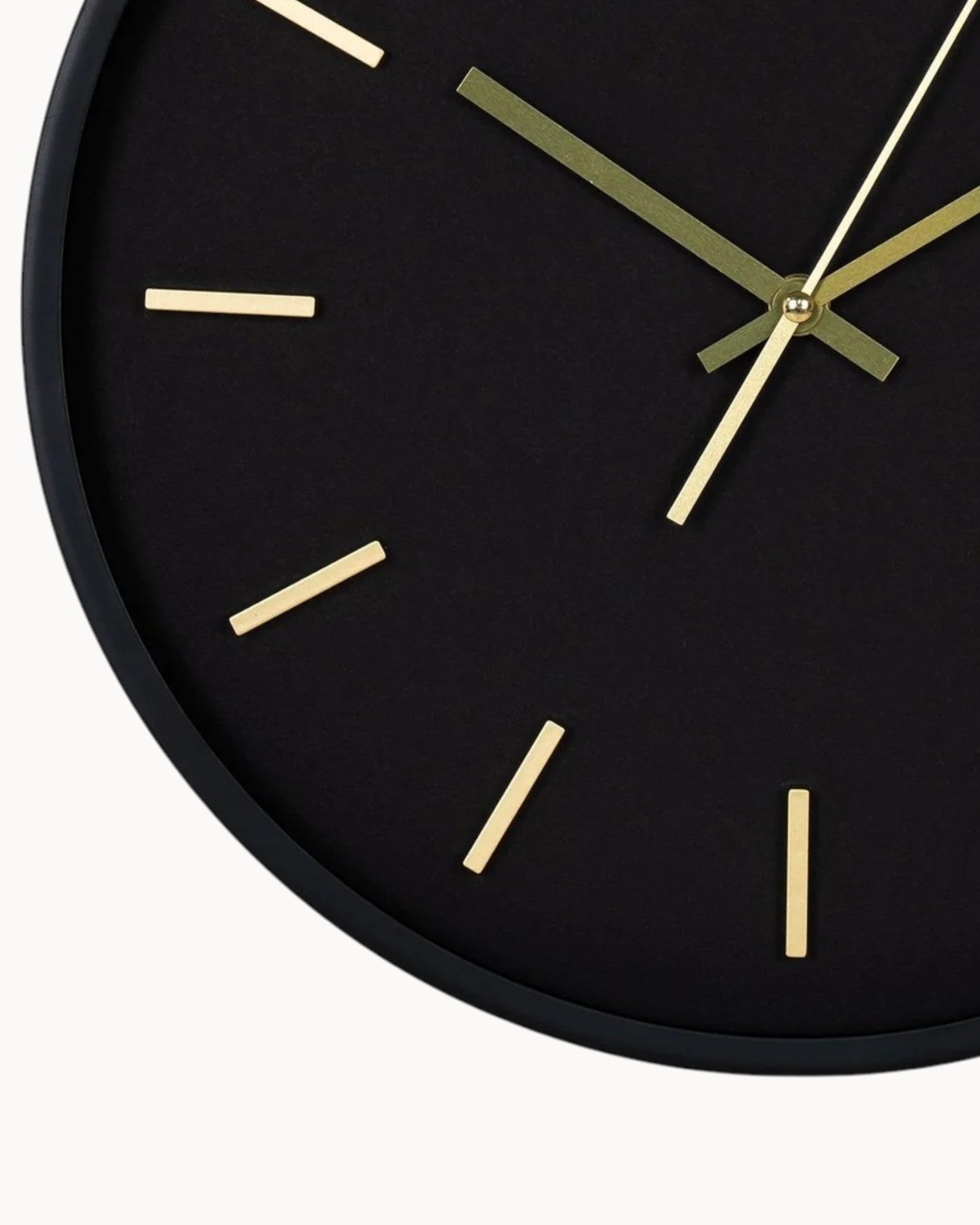 Black wall clock with gold hands on a white background