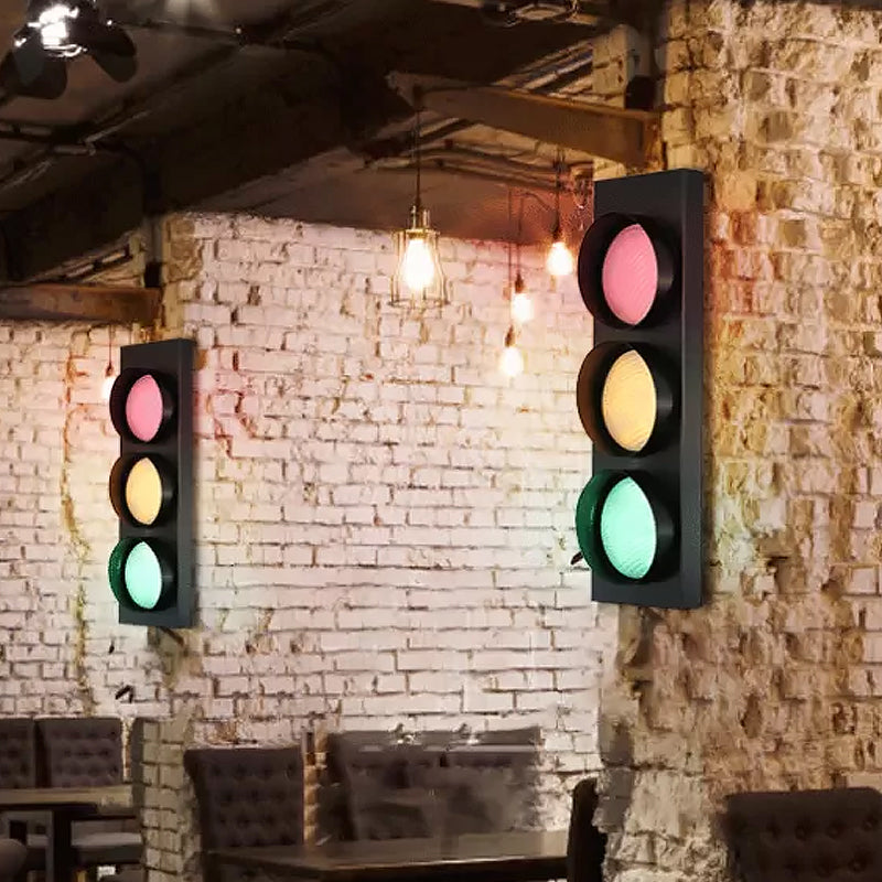 Traffic light-style lights on a brick wall with a bar setting.