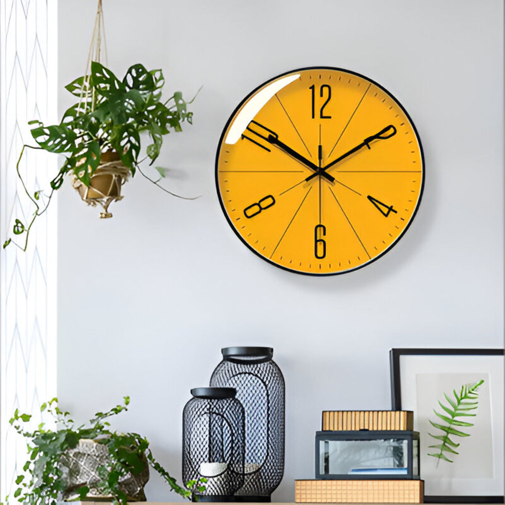Yellow wall clock on a white wall with decorative items below