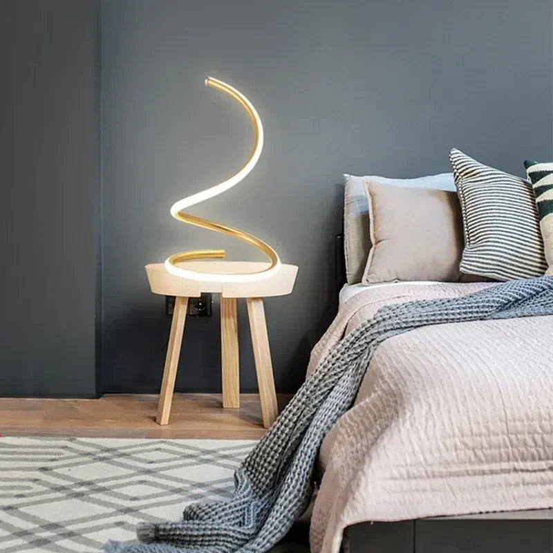 Modern bedroom with a curved LED lamp on a wooden side table.