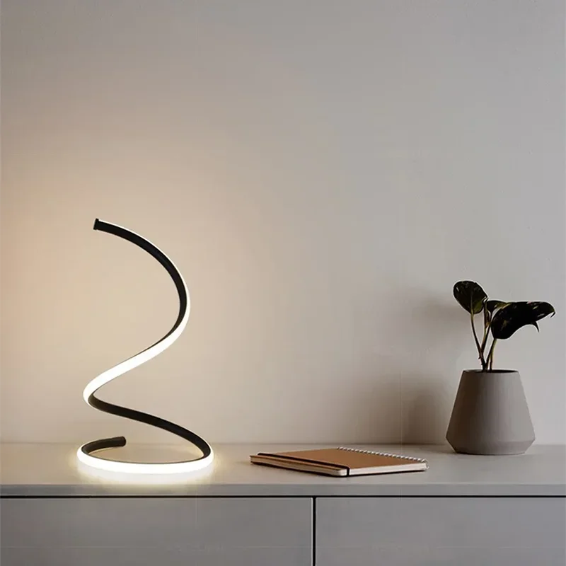 Modern desk lamp with a notebook and vase on a light surface against a neutral background