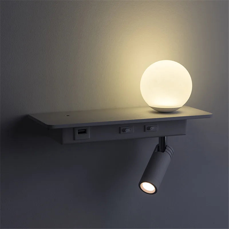 Wall-mounted light fixture with a spherical lamp and a cylindrical spotlight on a dark background