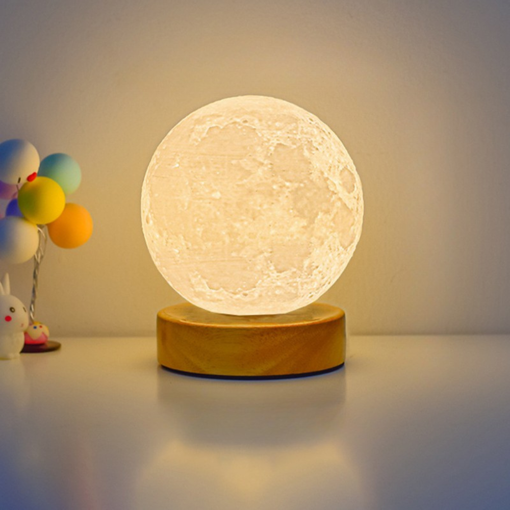 Moon lamp on a wooden base with colorful balloons in the background