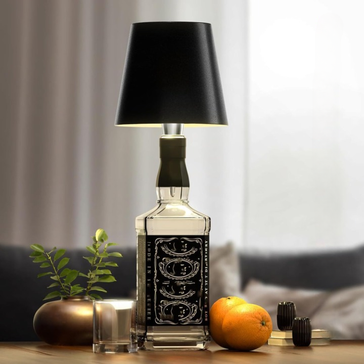 Table lamp made from a Jack Daniel's bottle with a black shade on a wooden surface.
