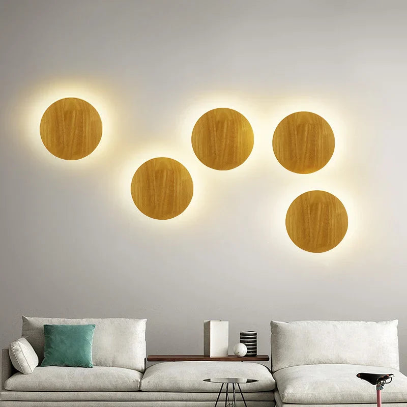 Wooden circular wall lights on a gray wall above a sofa.