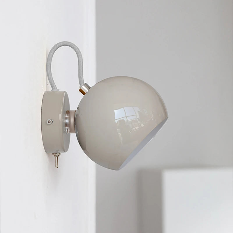 Wall-mounted lamp with a beige shade on a white wall