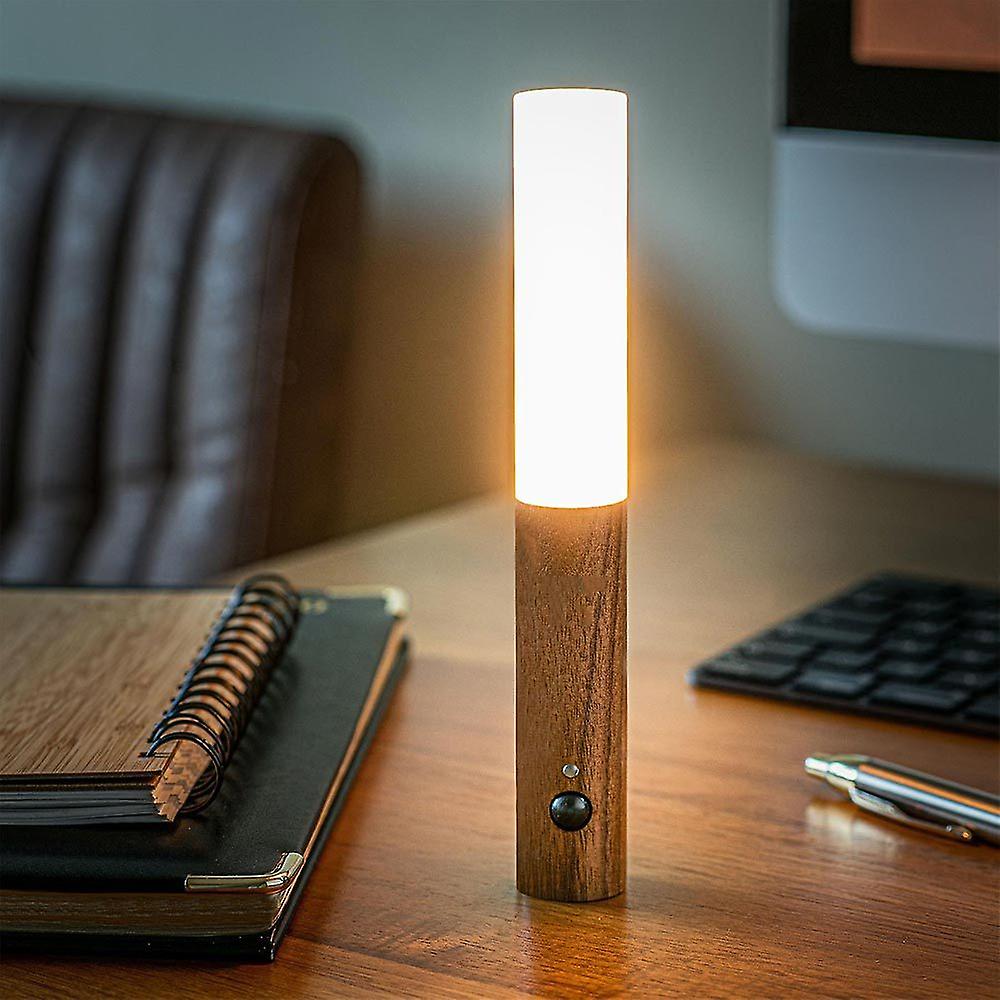 Wooden desk lamp on a desk with a notebook and pen