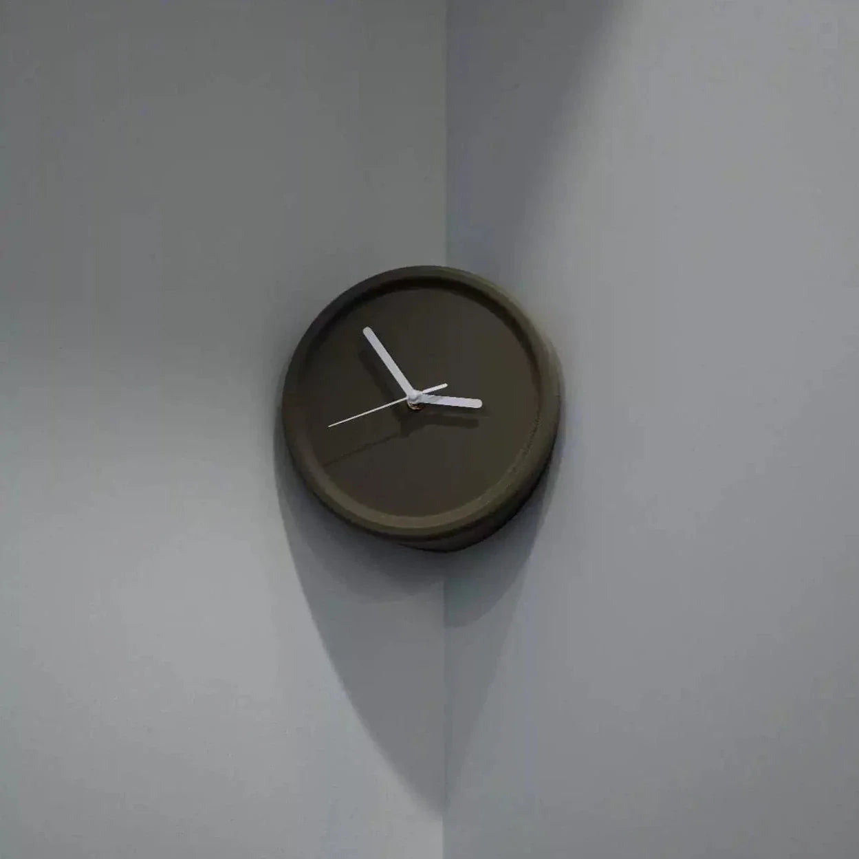 Wall clock with brown frame and white hands on a light gray wall