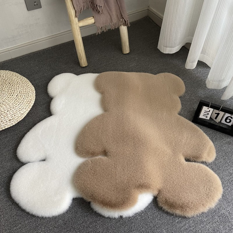 Fluffy bear-shaped rug on a carpeted floor with a curtain and stool in the background.