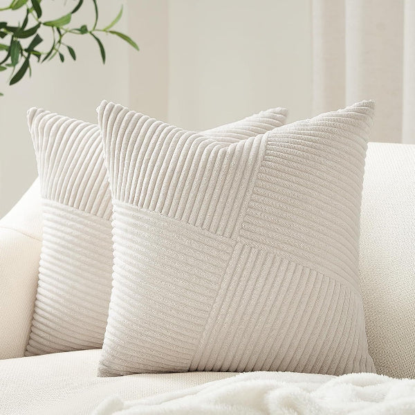Two beige textured pillows on a white sofa with a light background