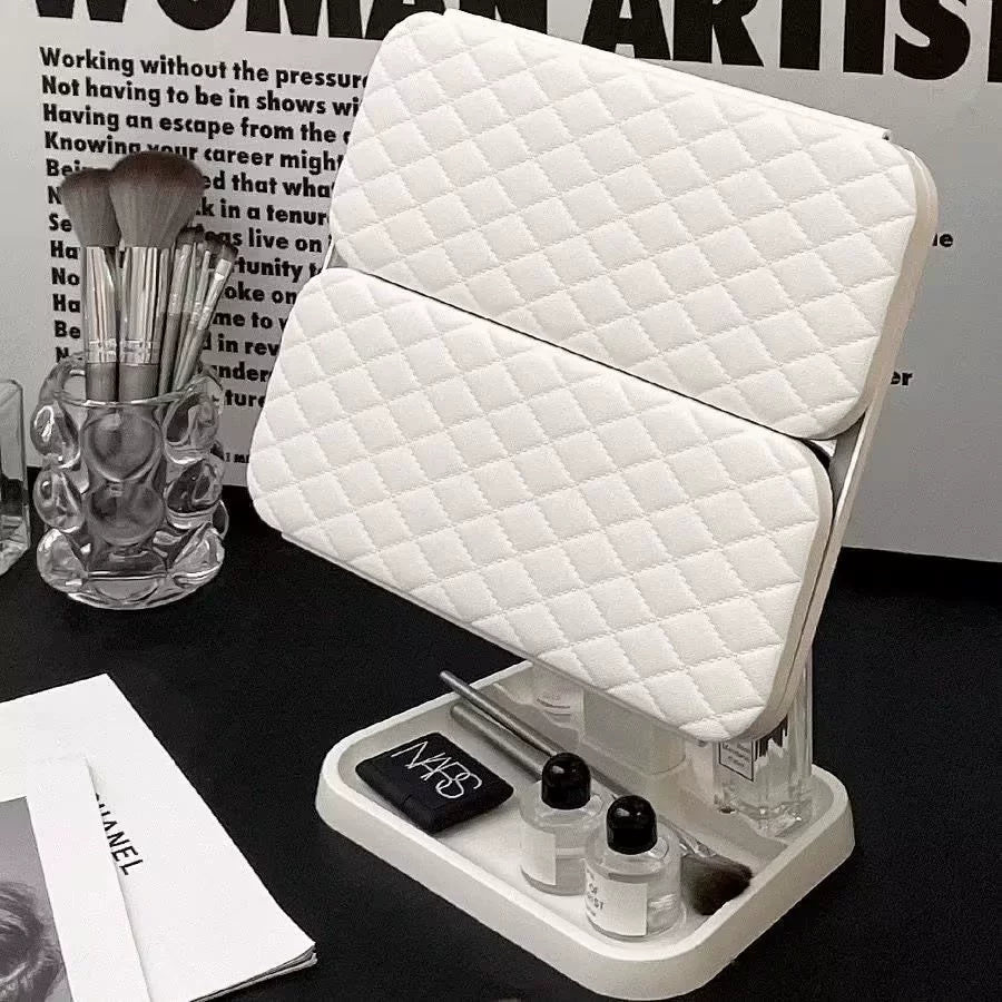 White quilted makeup chair with cosmetic items on a black surface