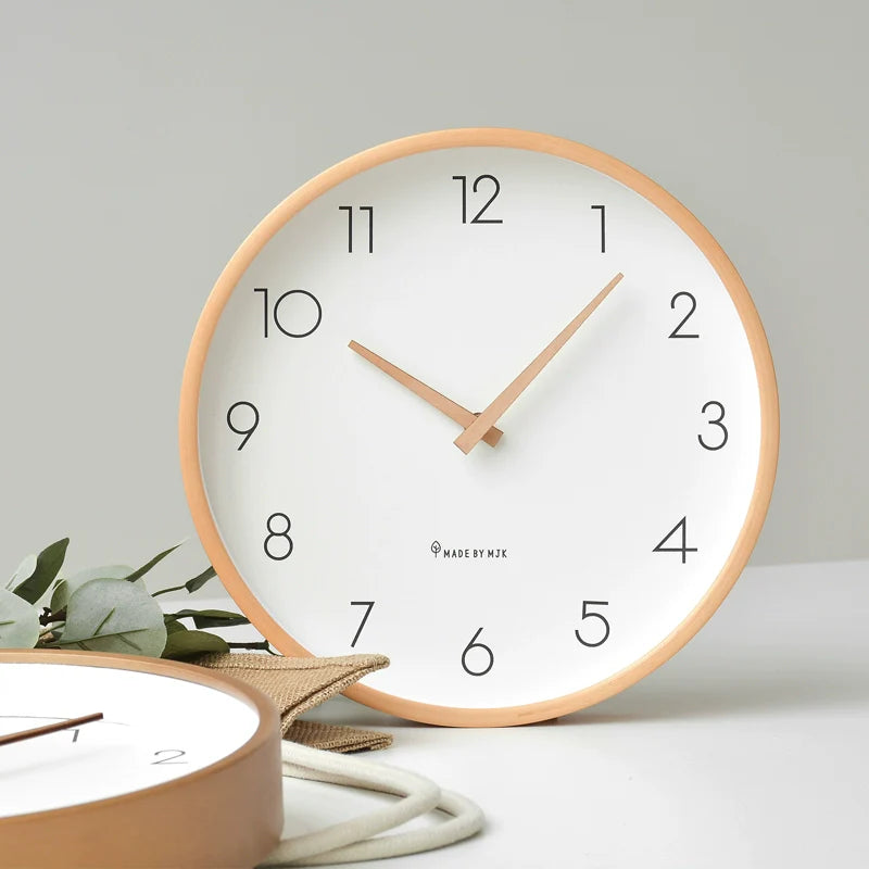 Round wall clock with wooden frame on a light gray background