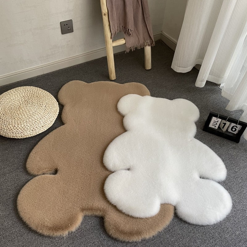 Two bear-shaped rugs, one brown and one white, on a gray floor with a chair and decorative items in the background.