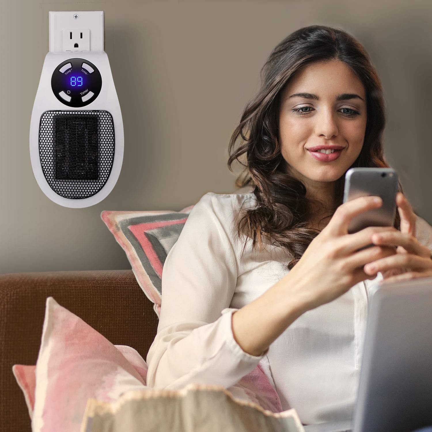Woman using a smartphone on a couch with a wall-mounted electric heater in the corner.