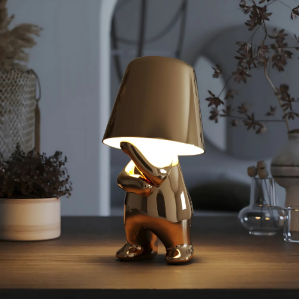 Decorative lamp shaped like a gnome on a wooden surface with a blurred background