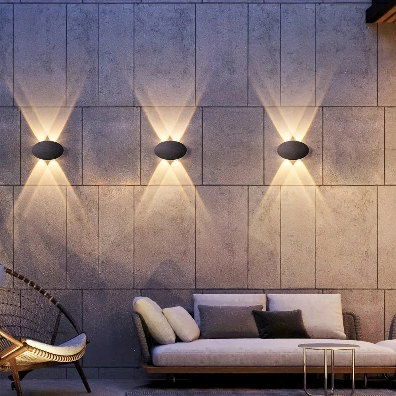 Modern wall lights on a textured wall with a sofa and chair in the foreground