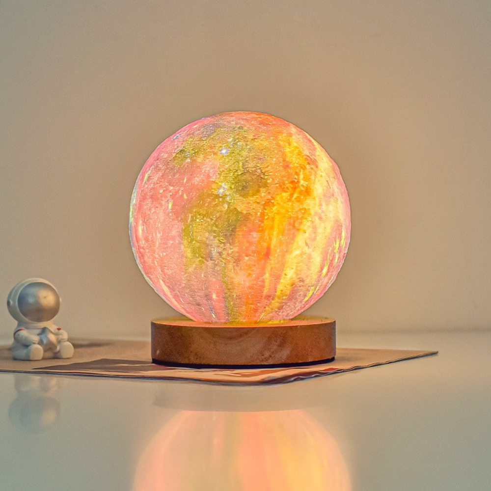 Colorful moon lamp on a reflective surface with a small figurine beside it.