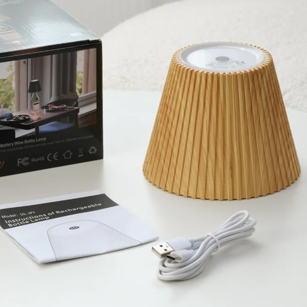 Small lamp with pleated design, USB cable, and packaging on a white surface