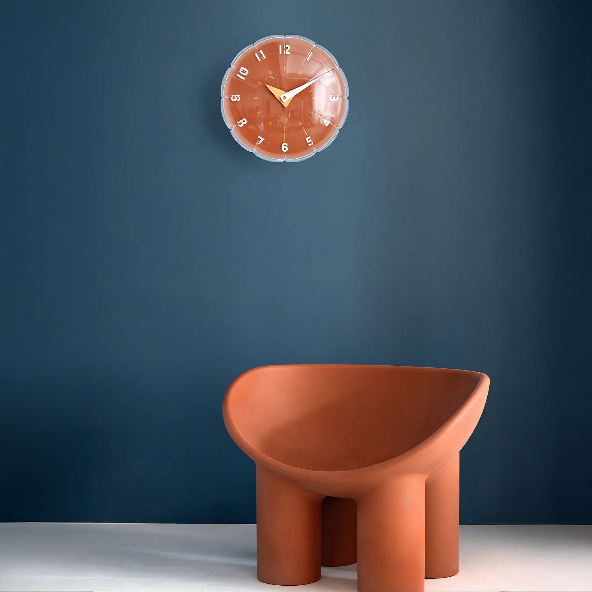 Terracotta chair and clock against a blue wall