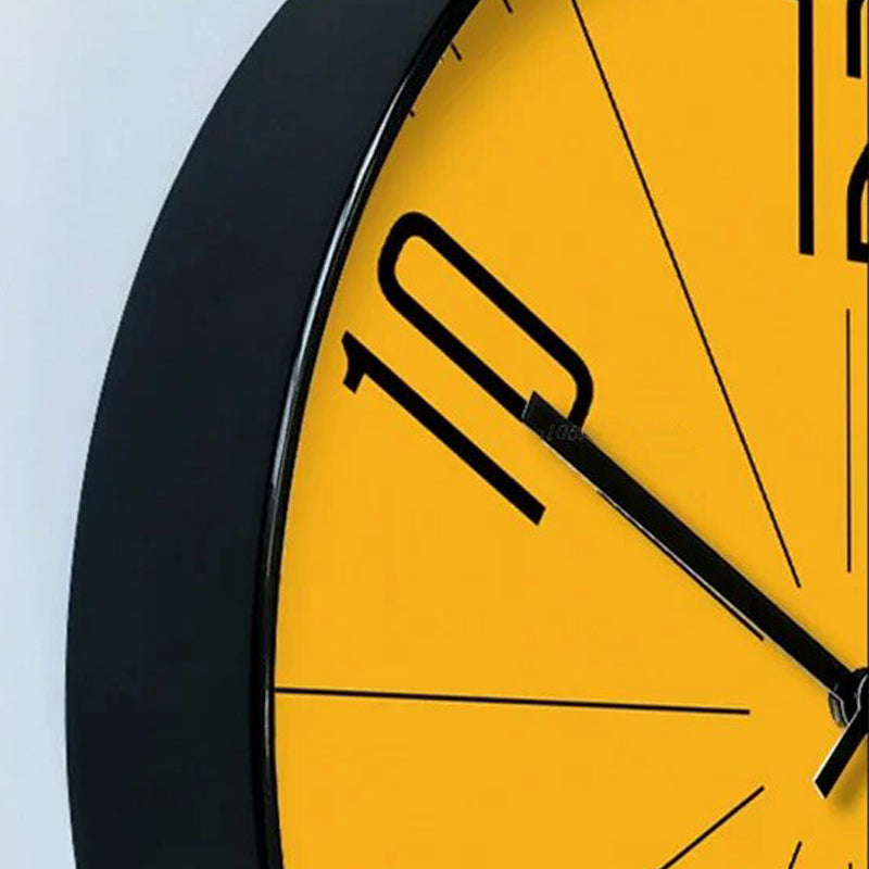 Close-up of a yellow clock face with black numbers and hands on a light gray background