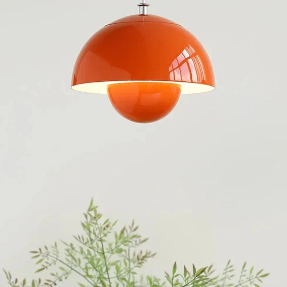 Orange pendant lamp on a white background with green plants at the bottom.