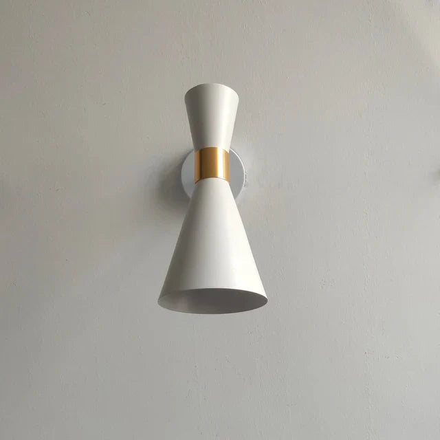 White wall light fixture with gold accent on a plain wall