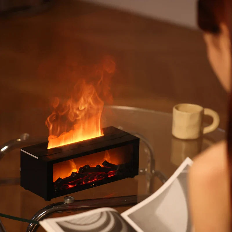 Small electric fireplace on a table with a mug and cards in the background