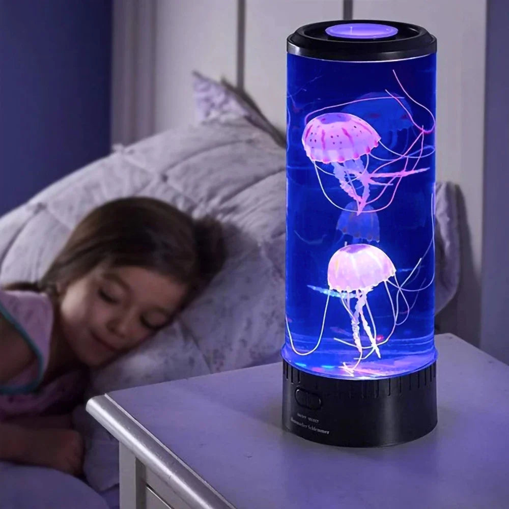 Lava lamp with jellyfish design on a bedside table next to a sleeping child.