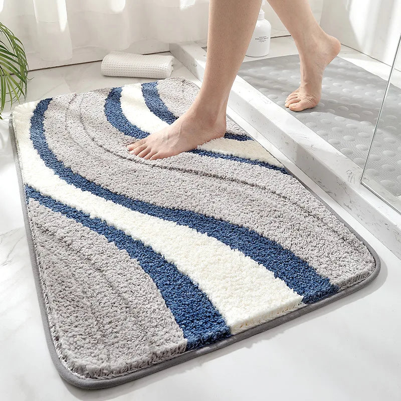 Person stepping onto a patterned bath mat with blue and white stripes on a bathroom floor.