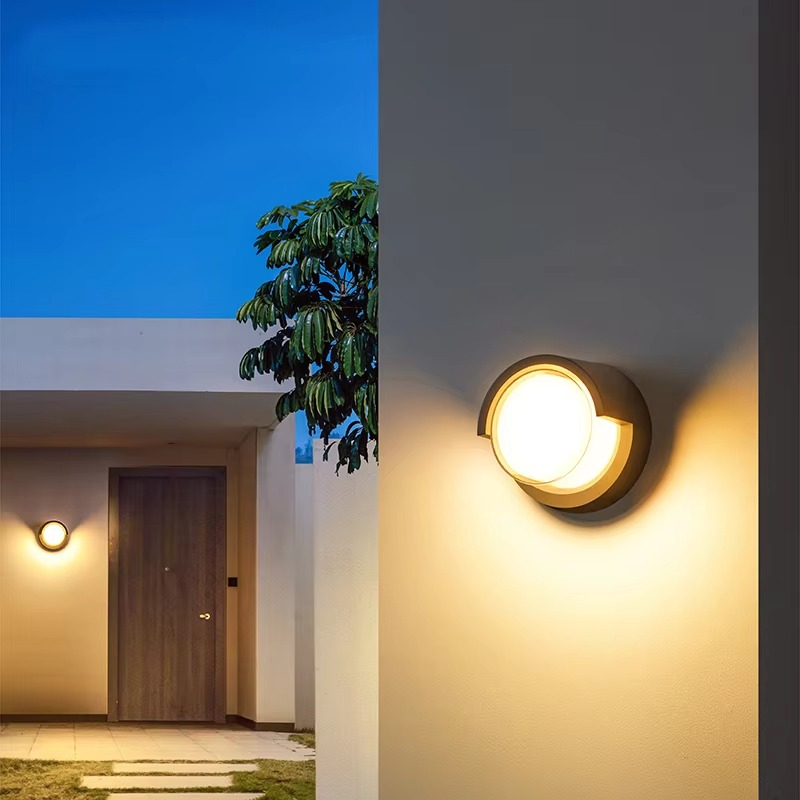 Modern outdoor wall lights on a building exterior with a clear blue sky.