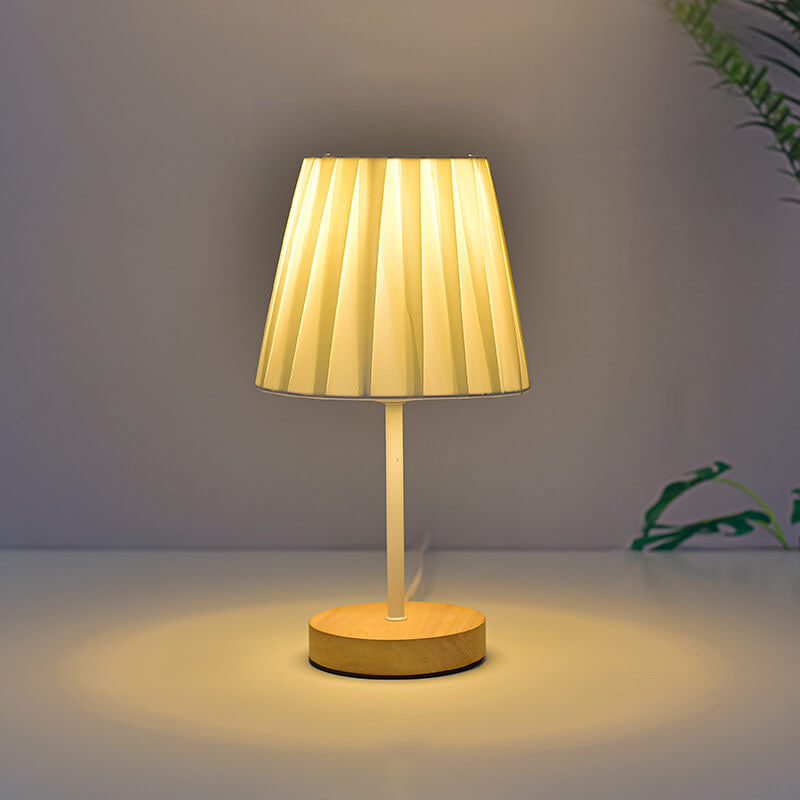 Table lamp with pleated shade on a neutral background