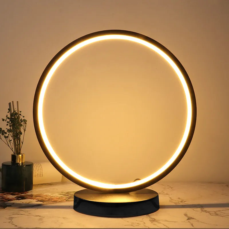 Round table lamp with illuminated ring on a marble surface