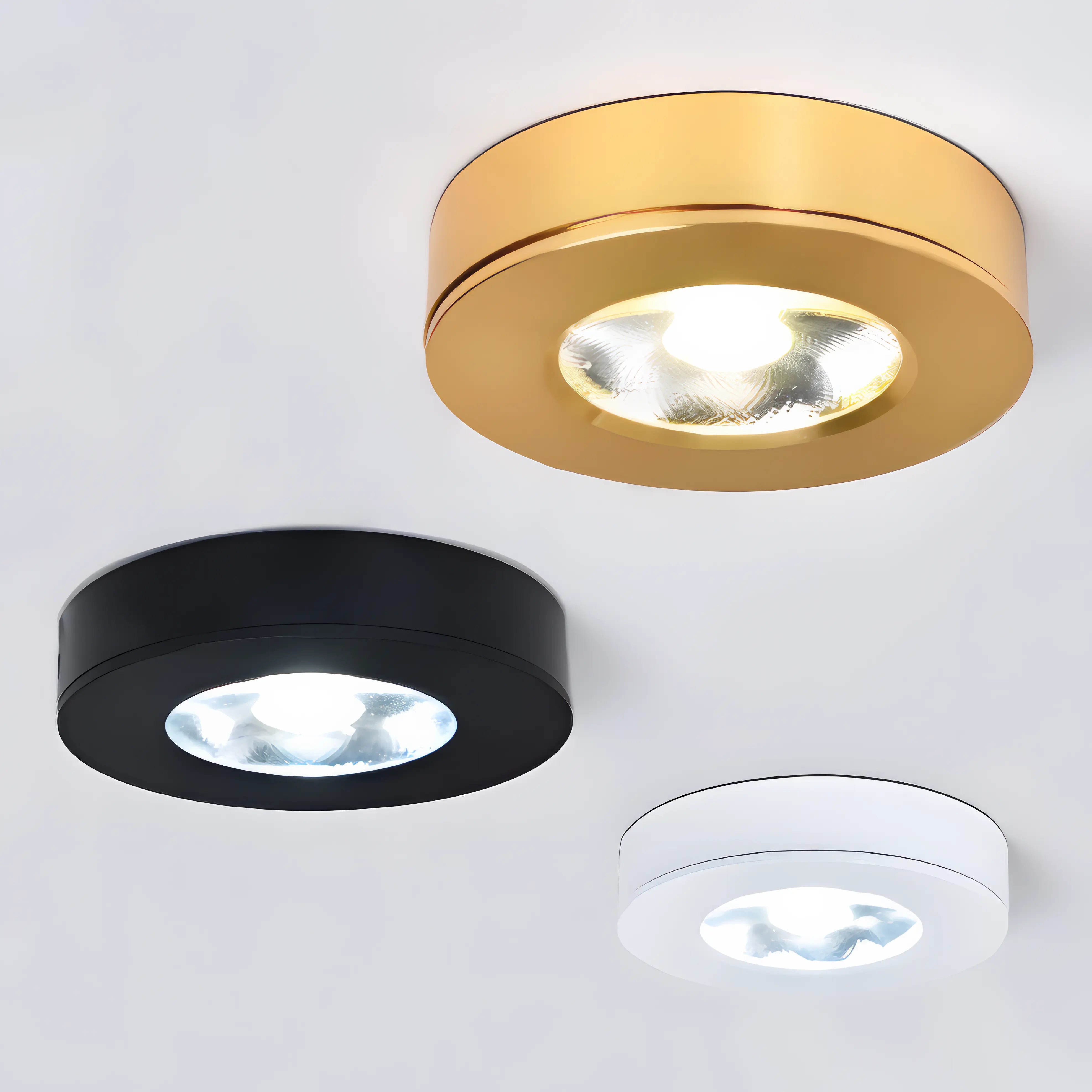 Three round ceiling lights in gold, black, and white on a white background