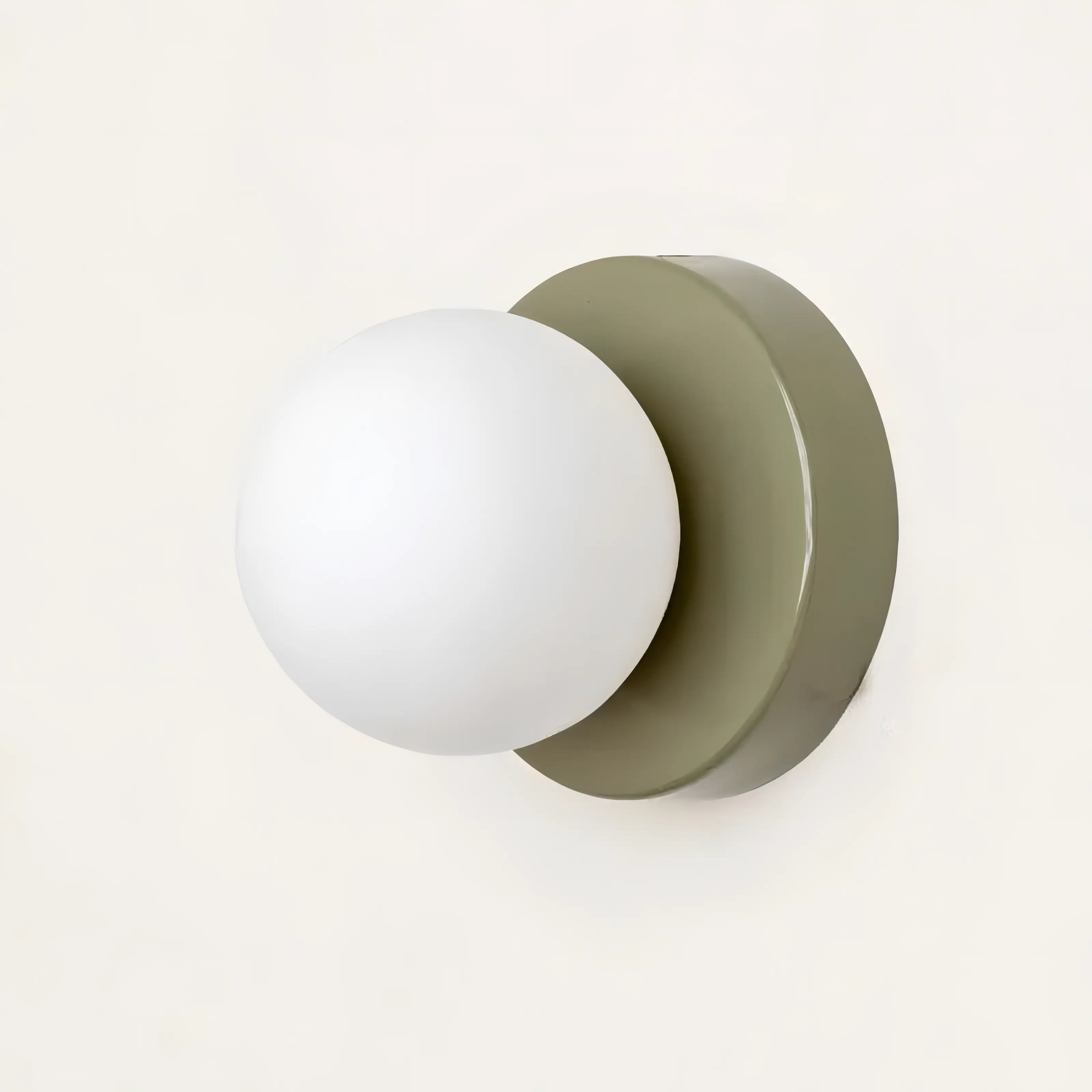 Wall-mounted light fixture with a white bulb and olive green base on a white background