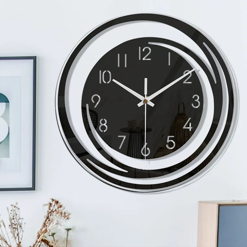 Modern wall clock with black face and white hands on a white wall.